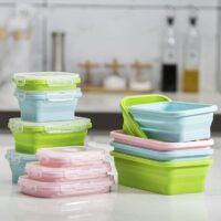 Collapsible silicone food container folded flat and expanded with meal inside.