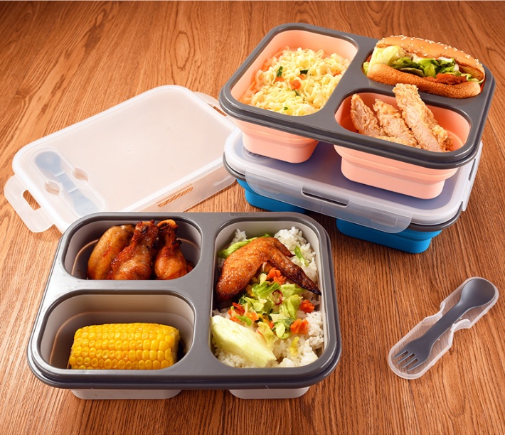 Collapsible silicone lunch box expanded with meal, folds flat for portable storage.