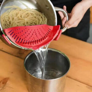   Clip-on silicone pot strainer attached to a pot while draining pasta